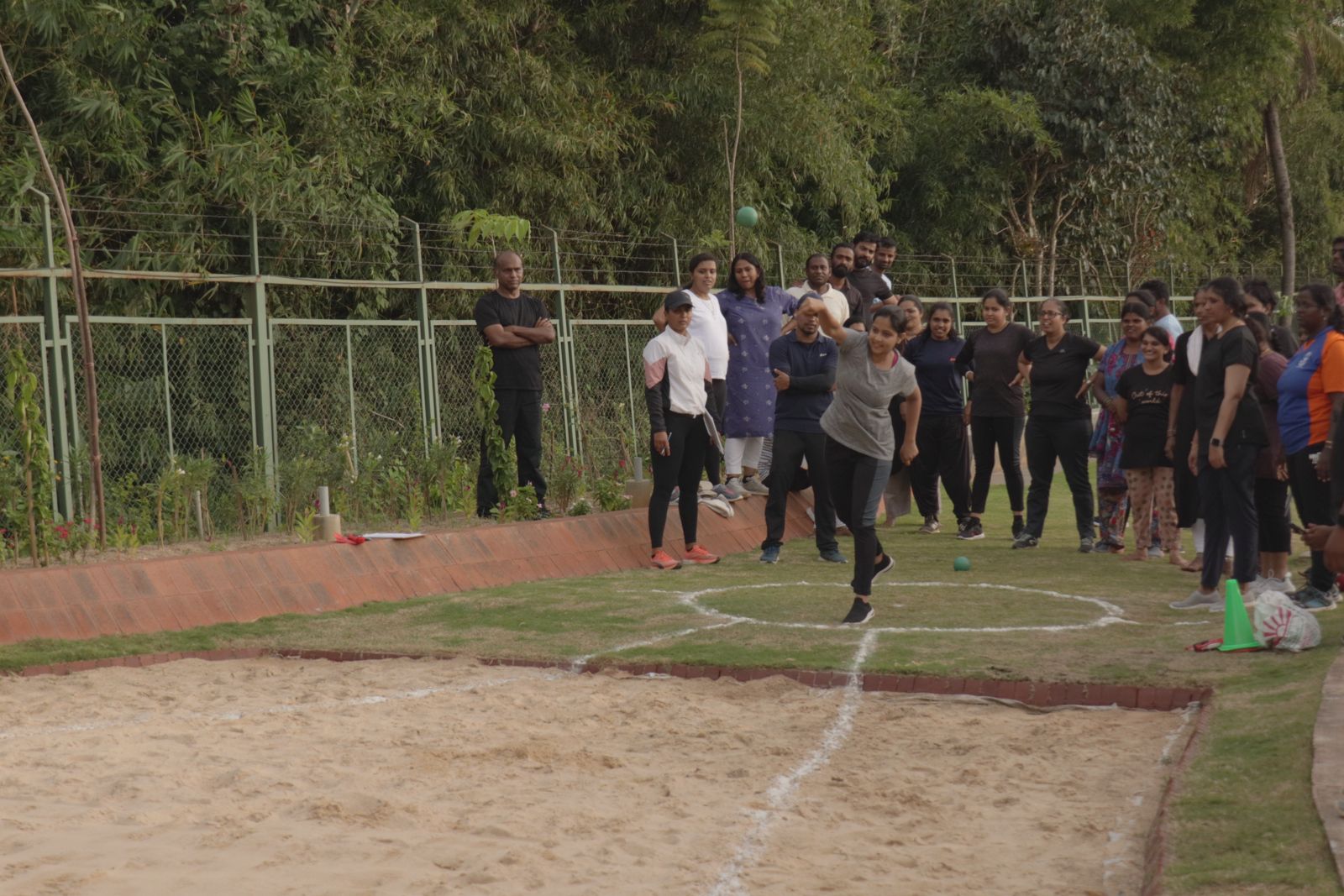 A colleague throwing a shot put as the team looks on