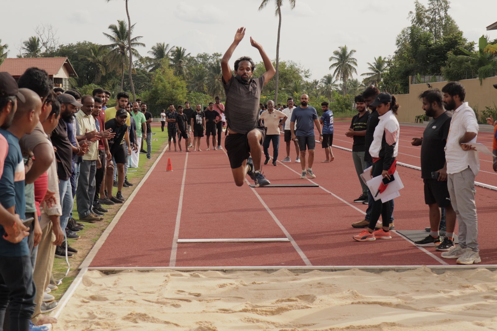 A colleague mid long jump as the team watches